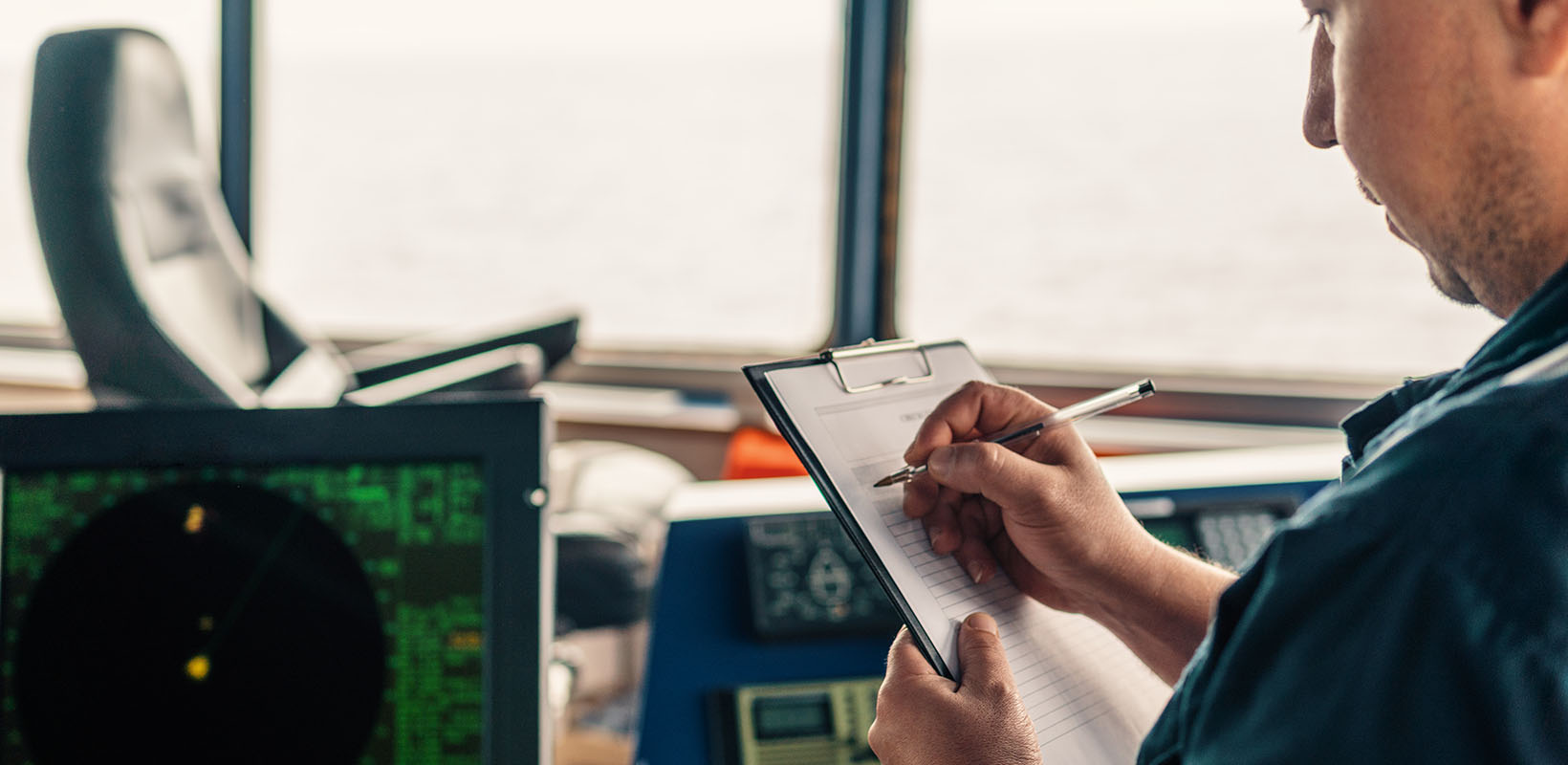 marinero inspeccionando tareas en el radar en el puente de un barco