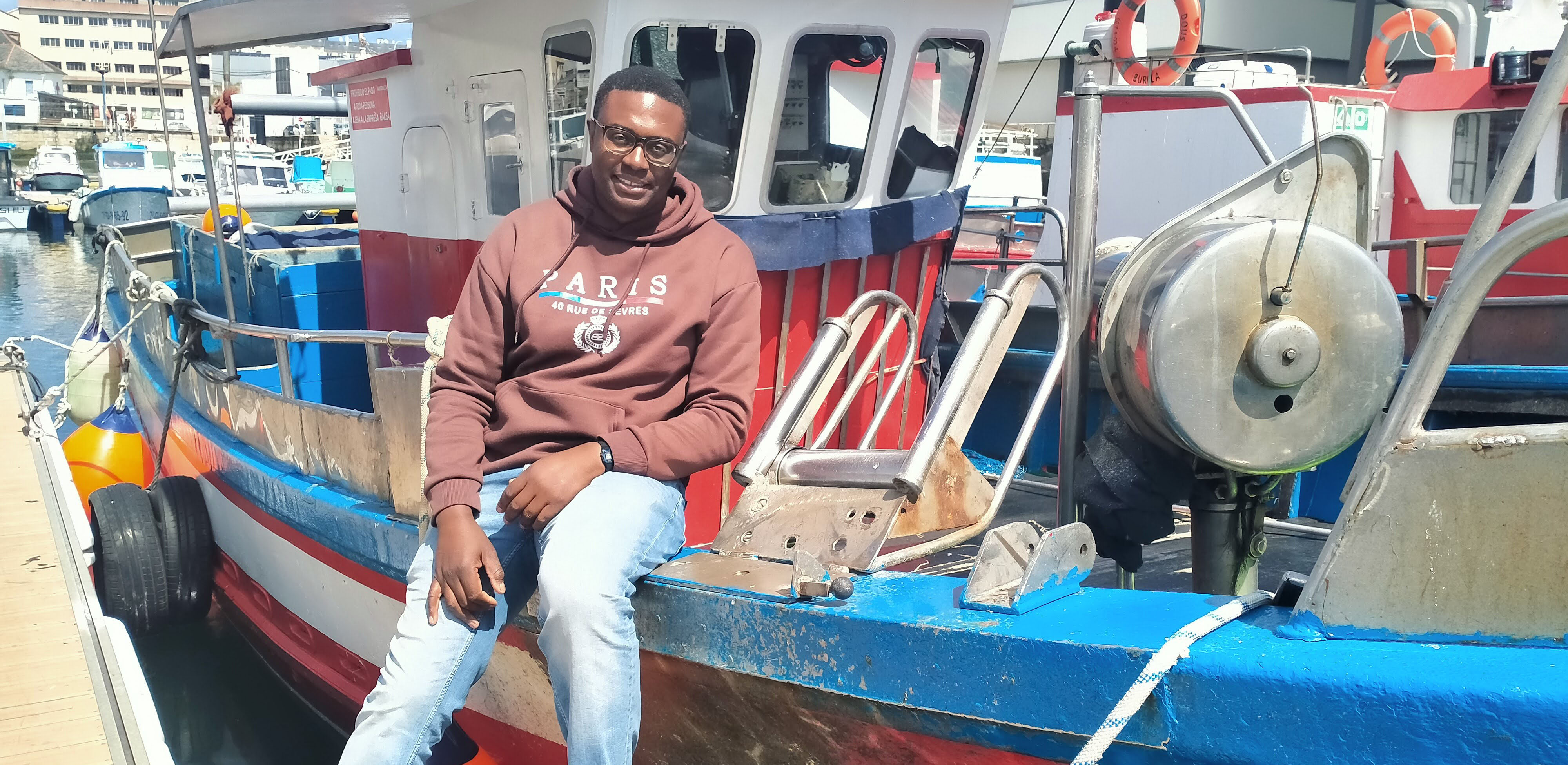 Pescador caboverdiano delante de su barco pesquero en Burela