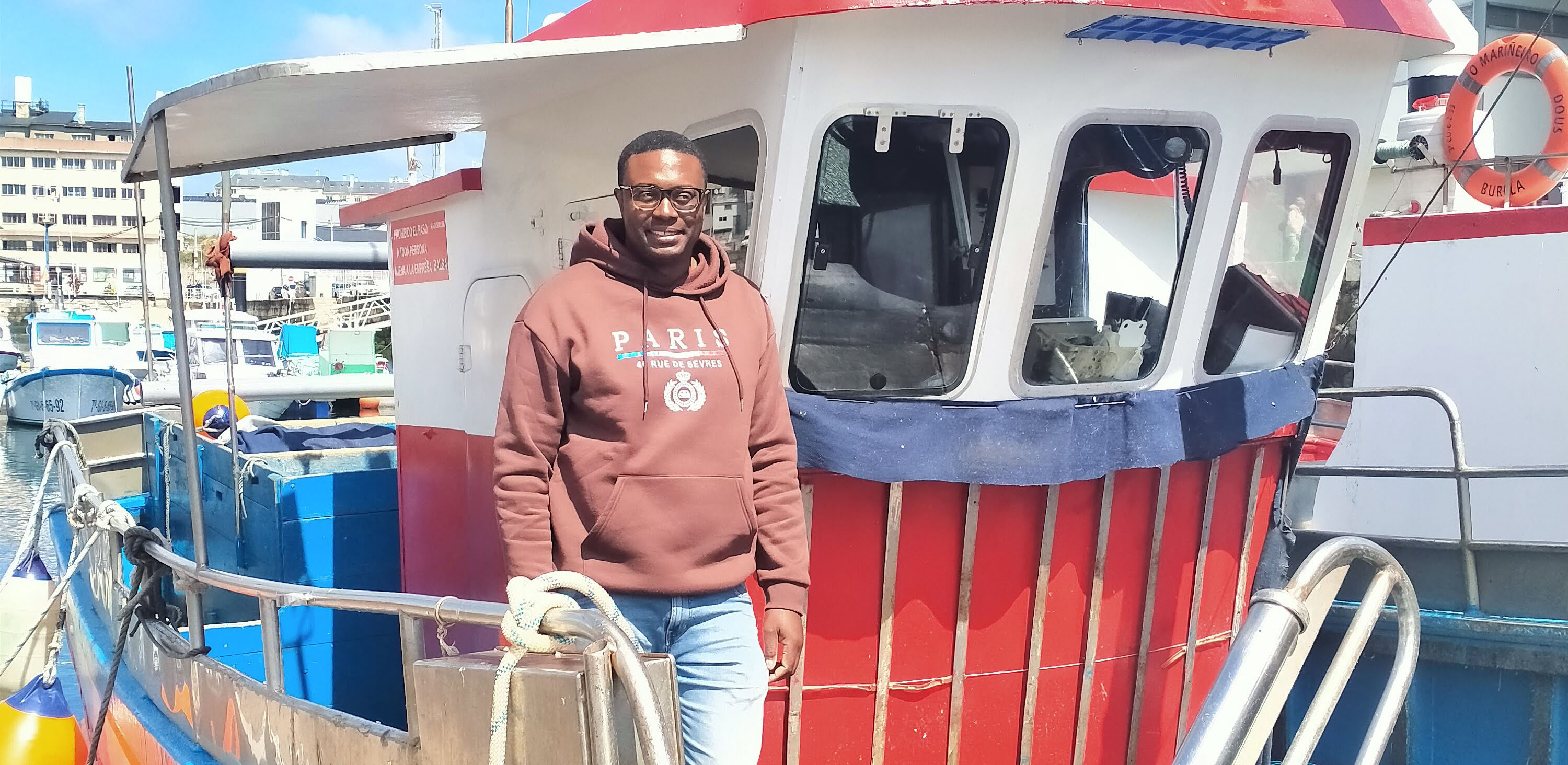 Pescador caboverdiano delante de su barco pesquero en Burela