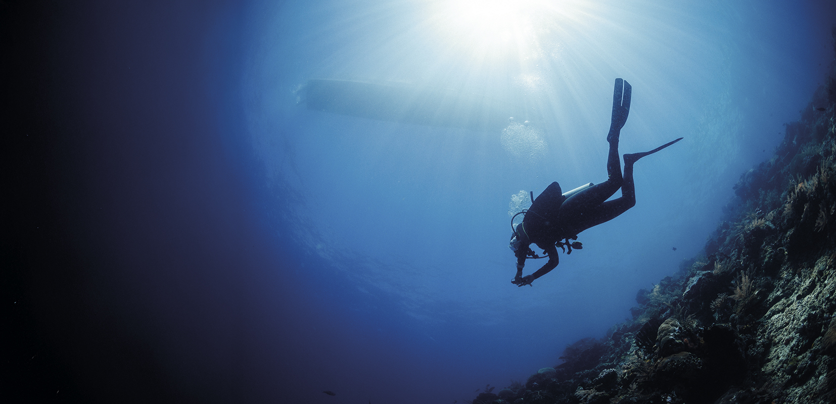 buzo en el mar con barco sobre su cuerpo
