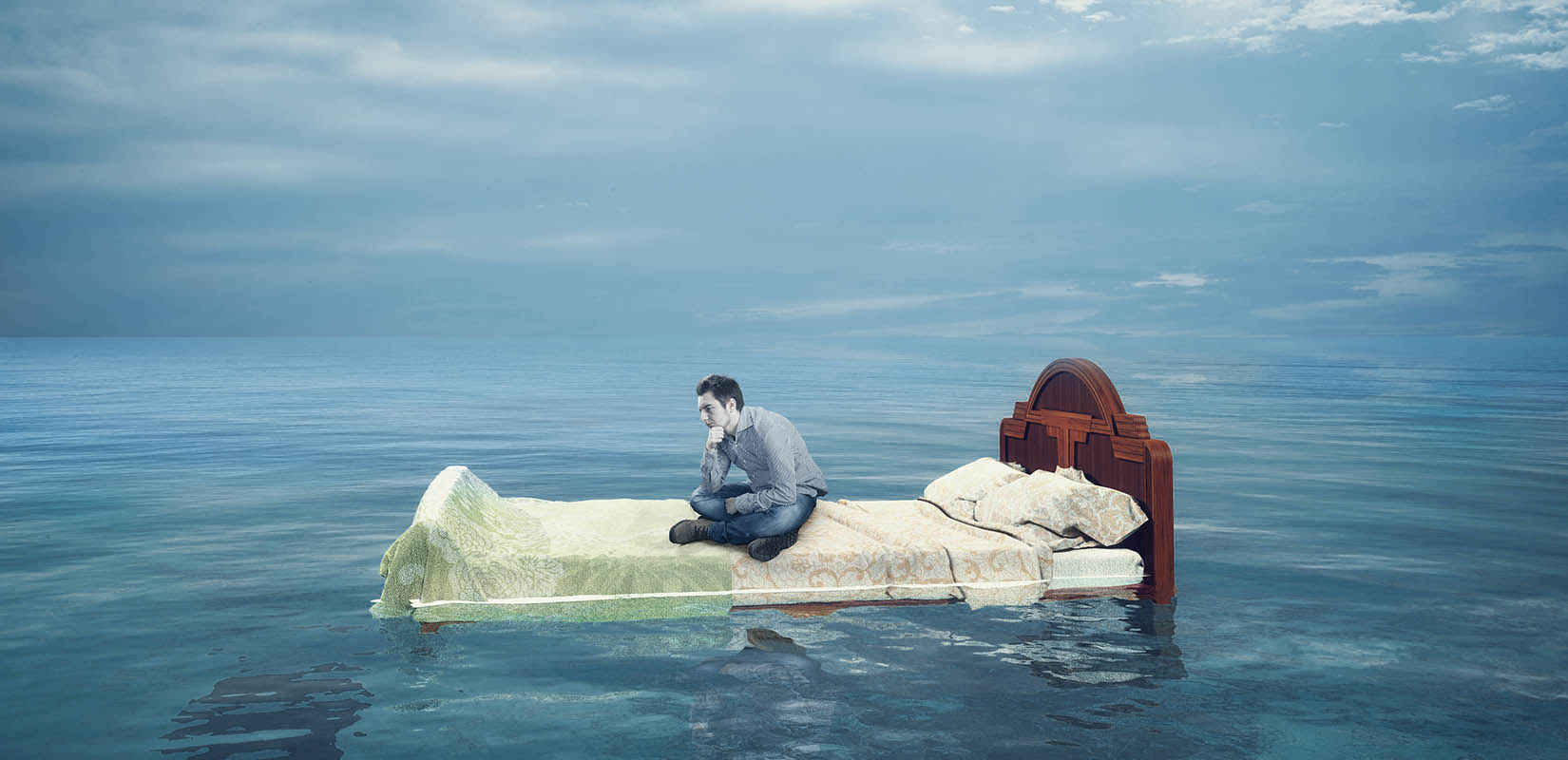 hombre sentando en lecho sobre el agua