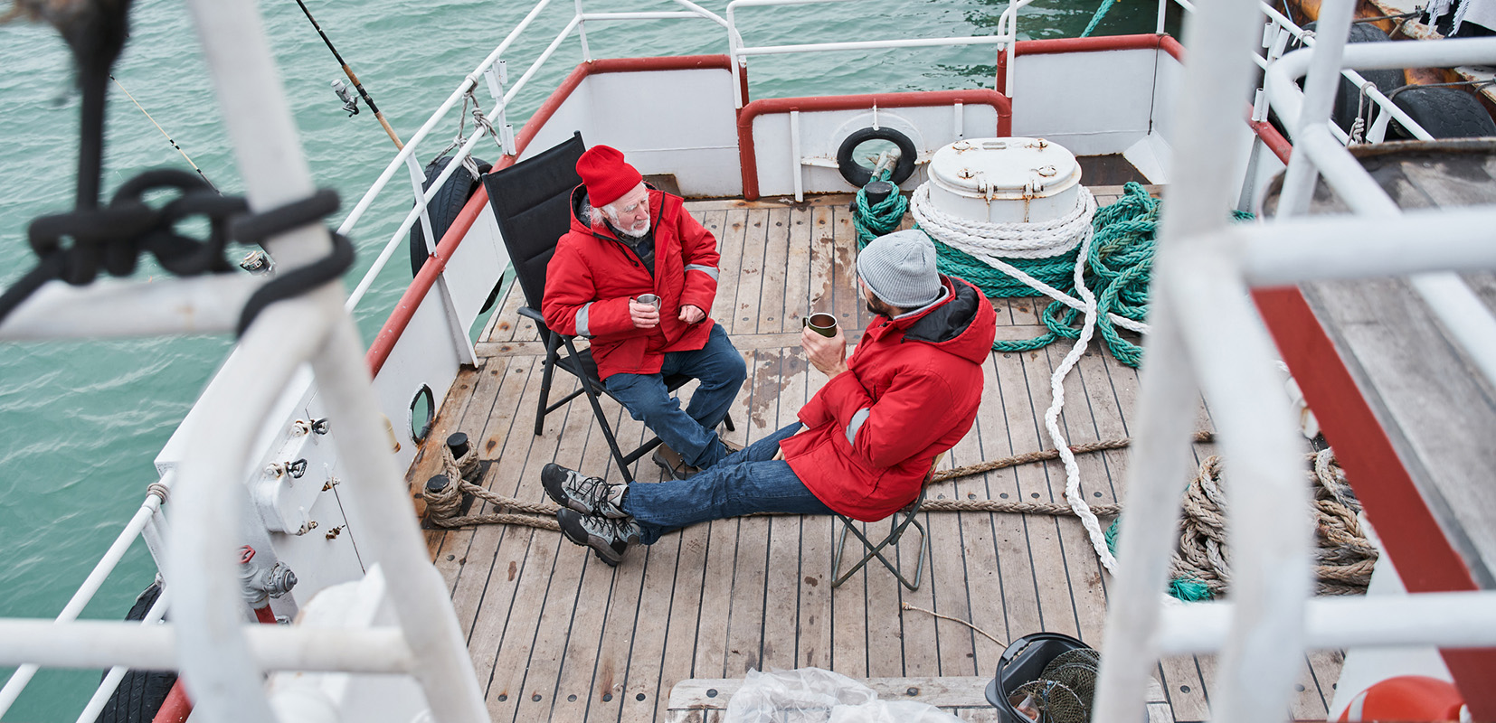 Dos pescadores tomando café en un barco