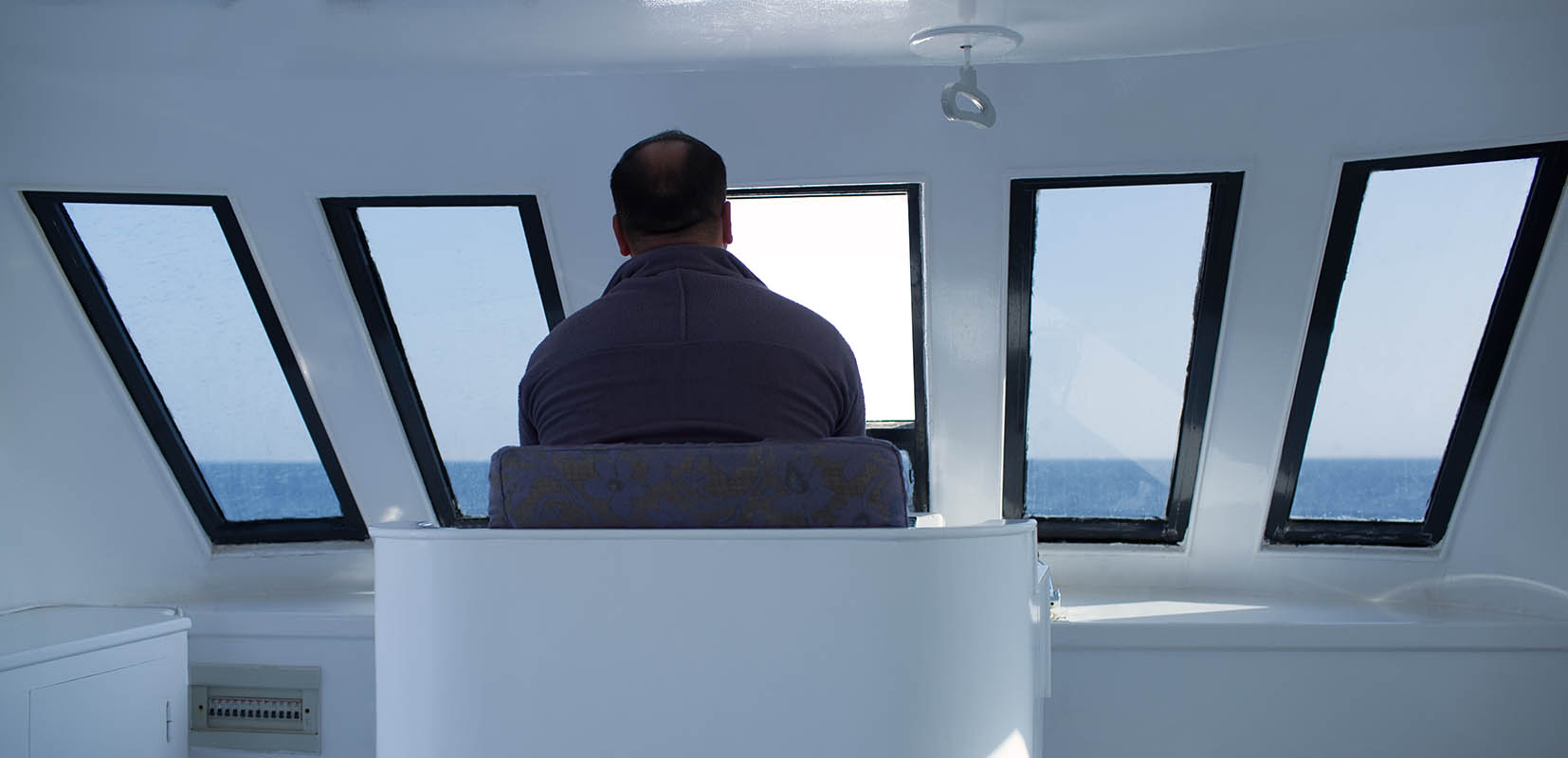 marinero mirando el mar desde el puente de mando