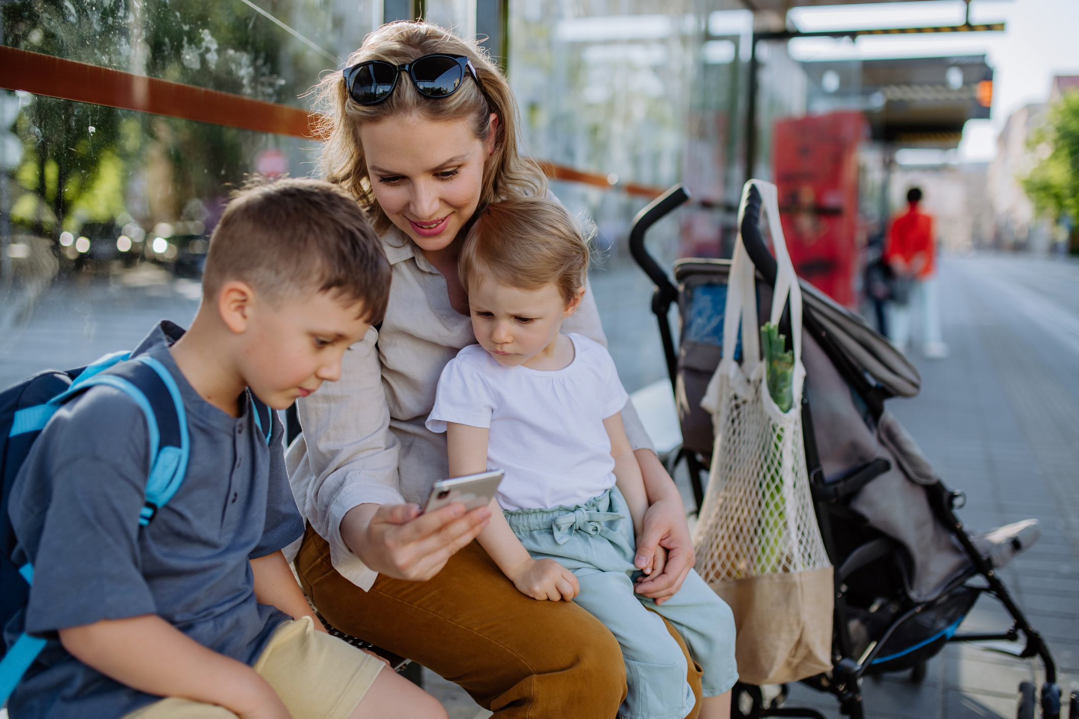 Mamá con sus hijos esperando el autobús